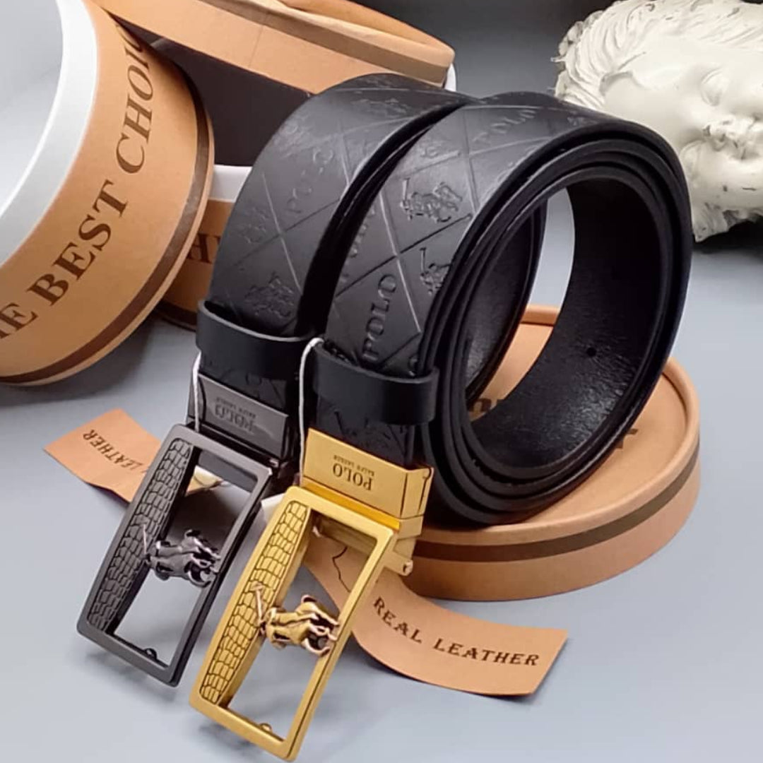 Black leather belt with gold buckle on a gray surface, surrounded by decorative items.